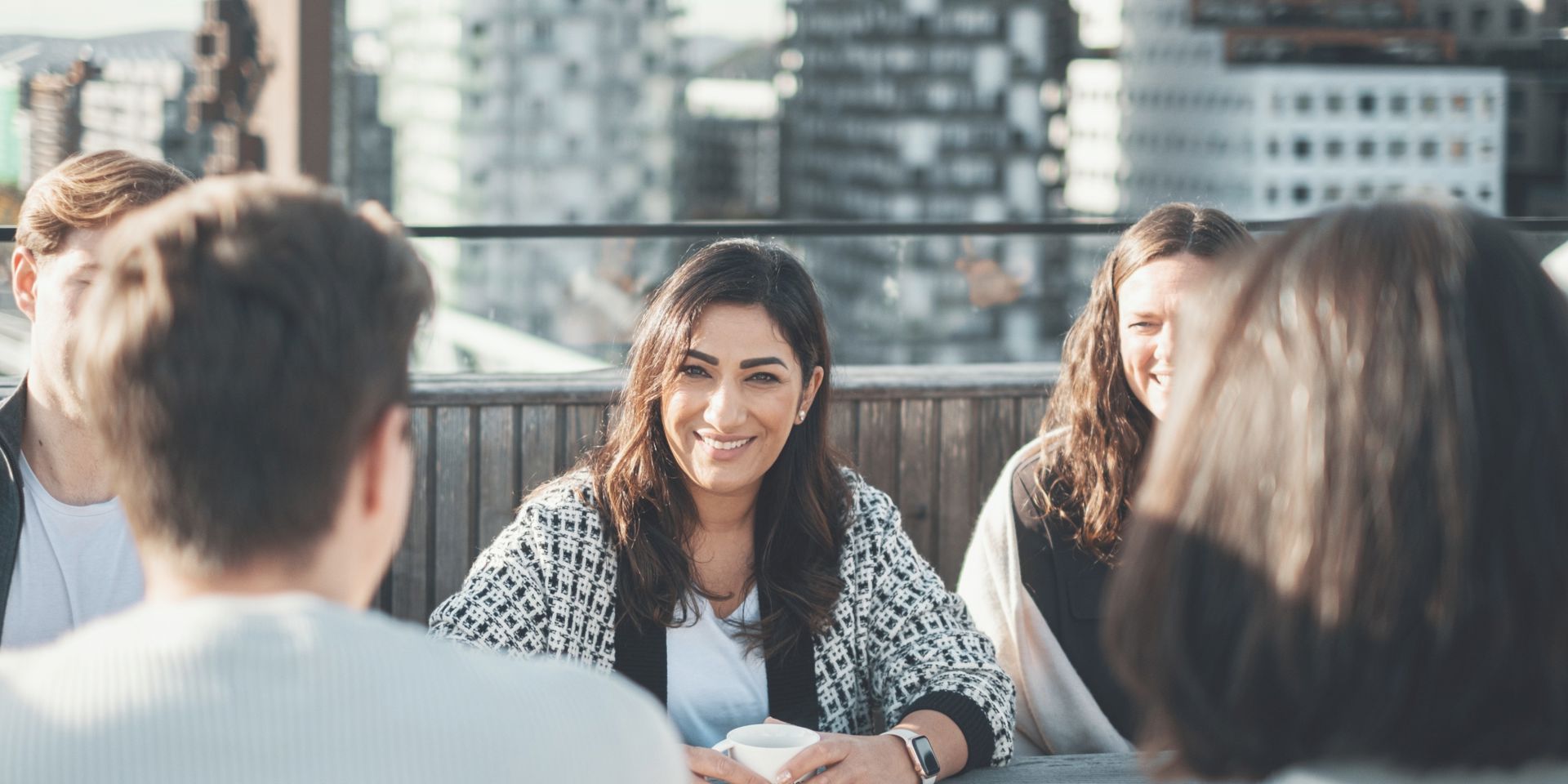 Fem ansatte i Bane NOR er samlet på taket for en sosial prat