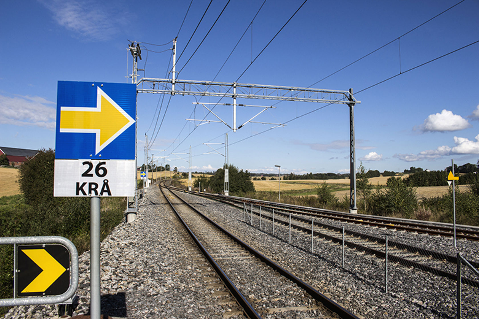Bildet viser en jernbanestrekning med jernbanespor som ligger over et flatt jorde
