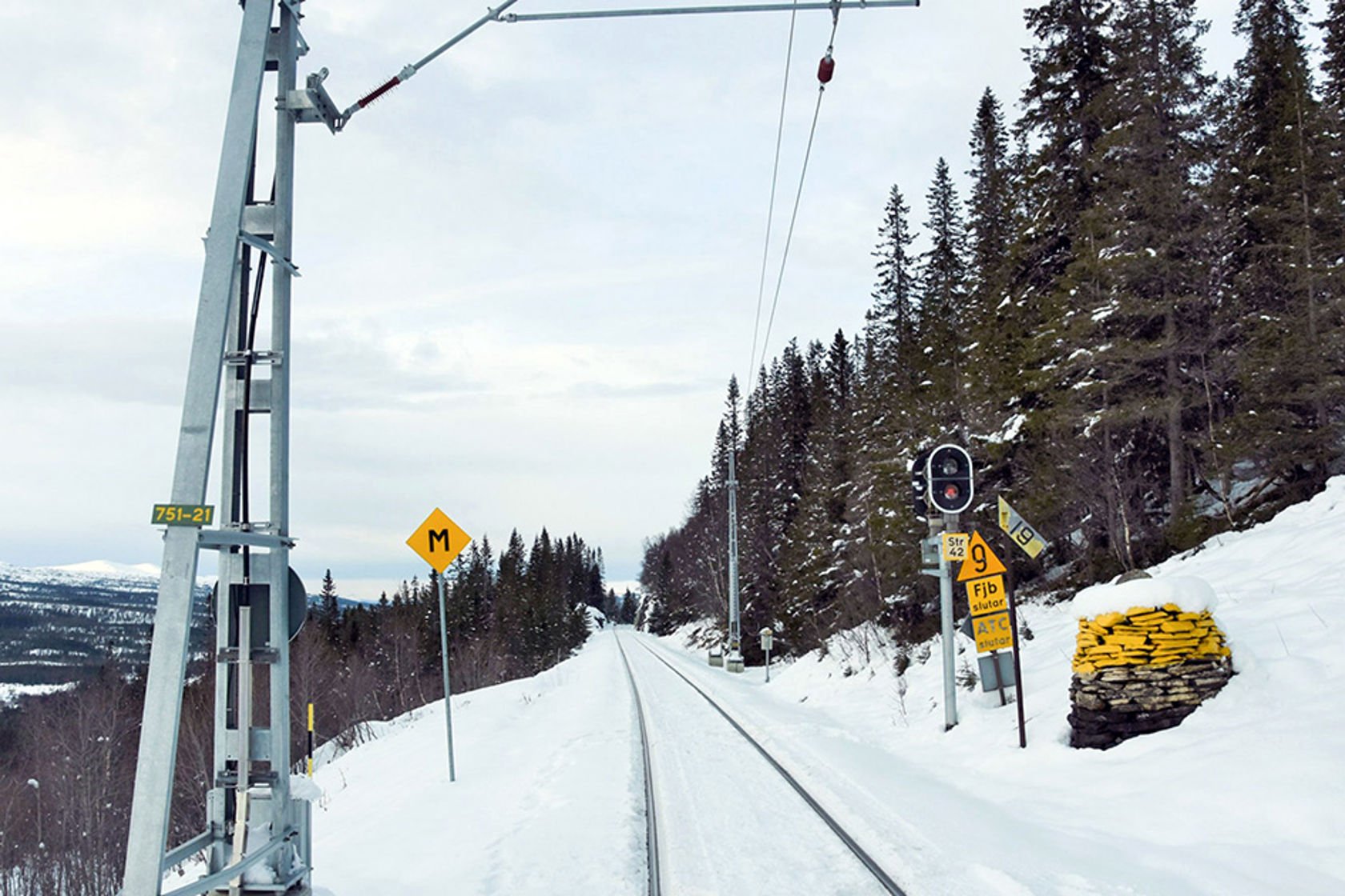 Her er det slutt på strømmen. Bildet viser siste mast på Meråkerbanen på grensa mellom Sverige og Norge.