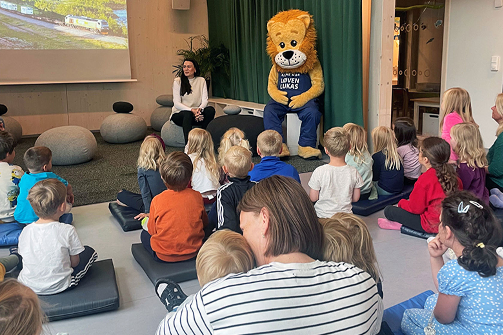 En samling av barn og en kvinne som snakker til dem