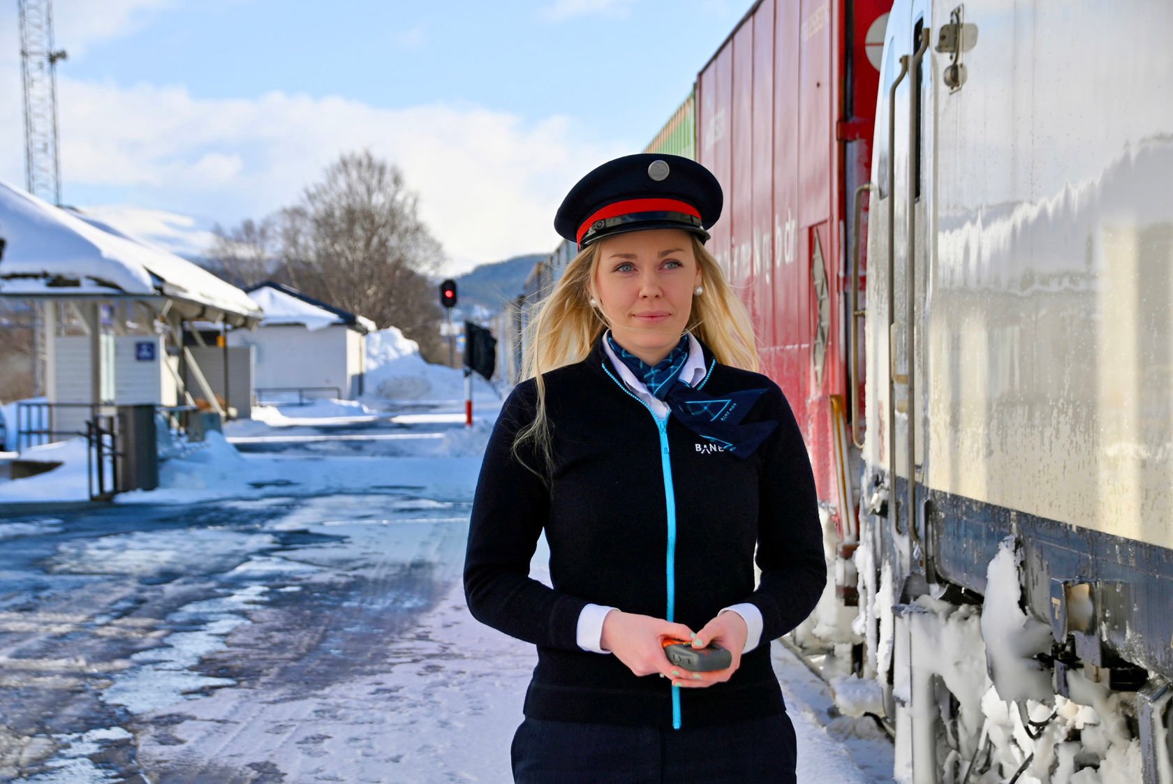 Bilde av ei kvinne i trafikkstyraruniform ved eit tog.