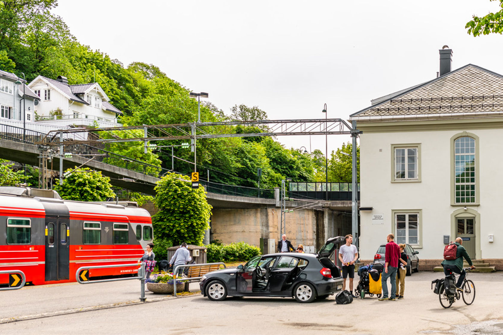 Bilde av togstasjon med parkert bil.