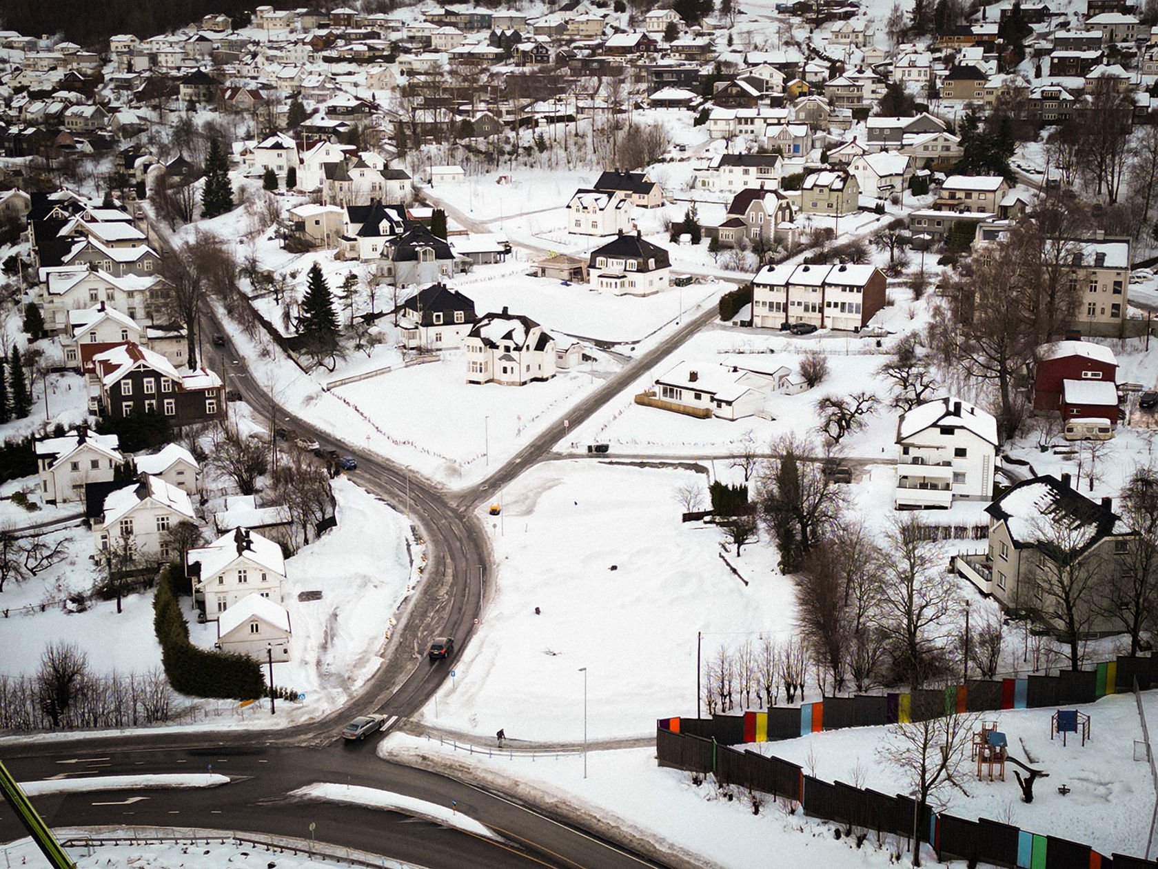 Vinterkledd boligområde med mange eneboliger fotografert med drone.