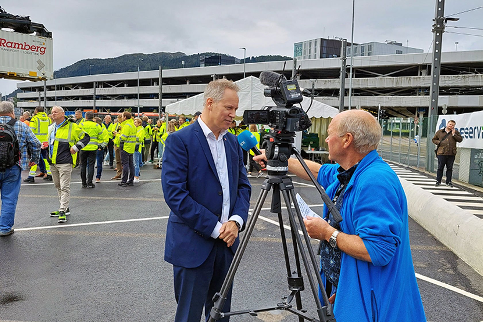 Mann i dress blir intervjuet av mann med TV-kamera.