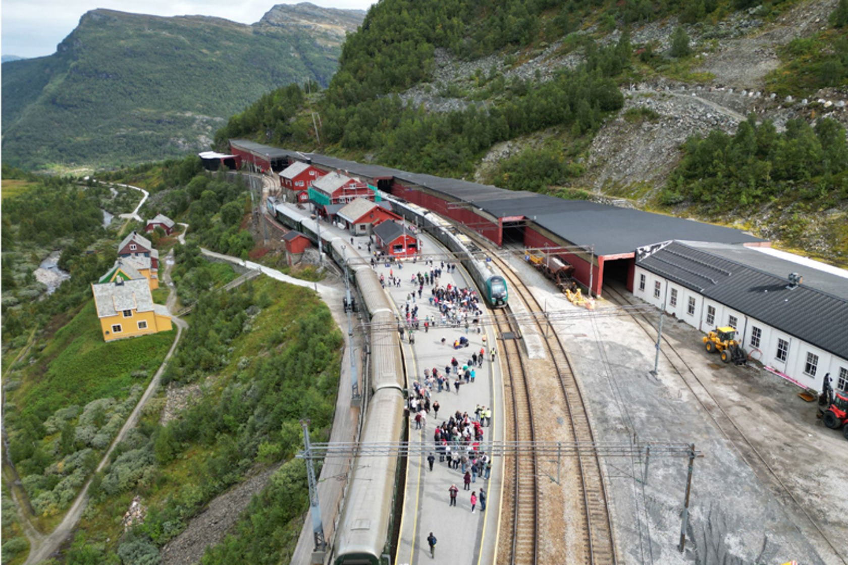 Bildet viser tog, spor, plattform og stasjonsbygninger