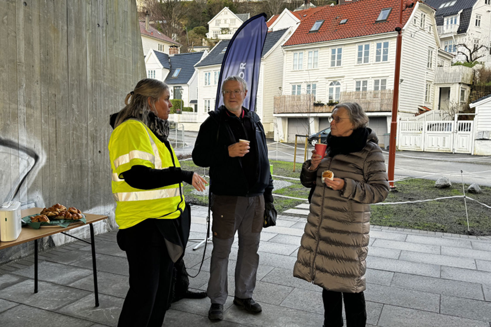 Personer som prater og spiser boller og drikker kaffe