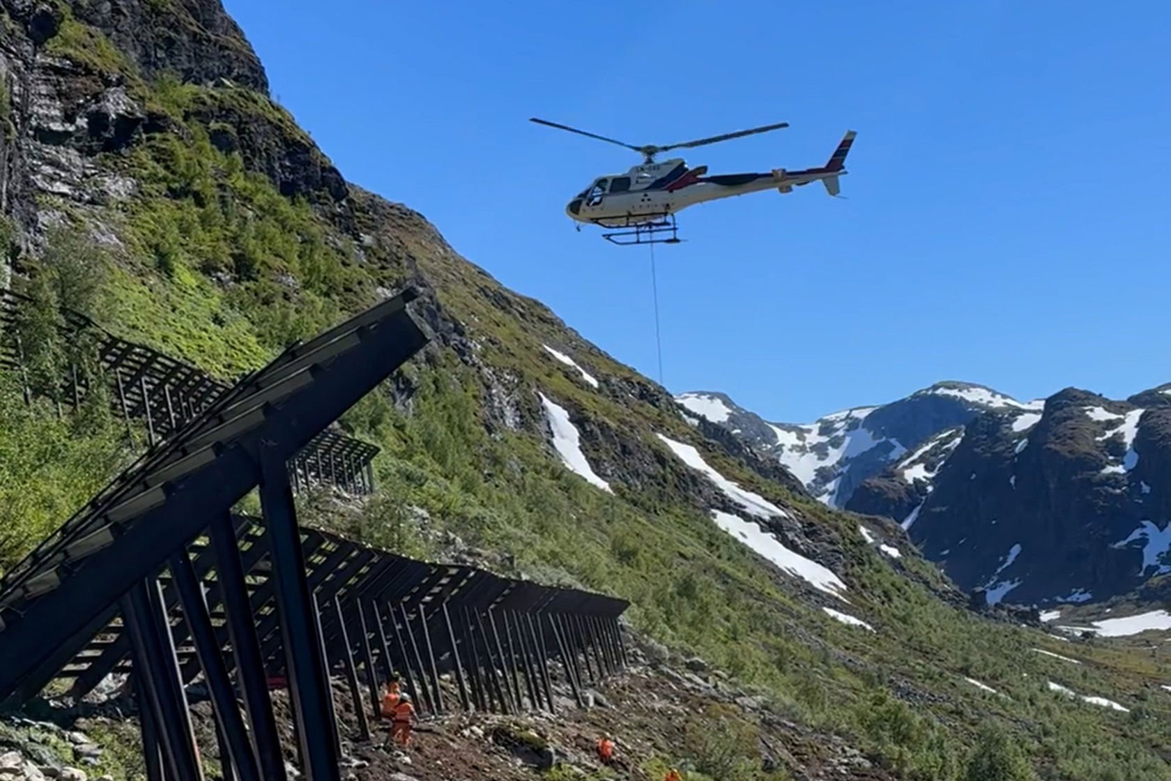  Helikopter som heiser ned materiell i en fjellside