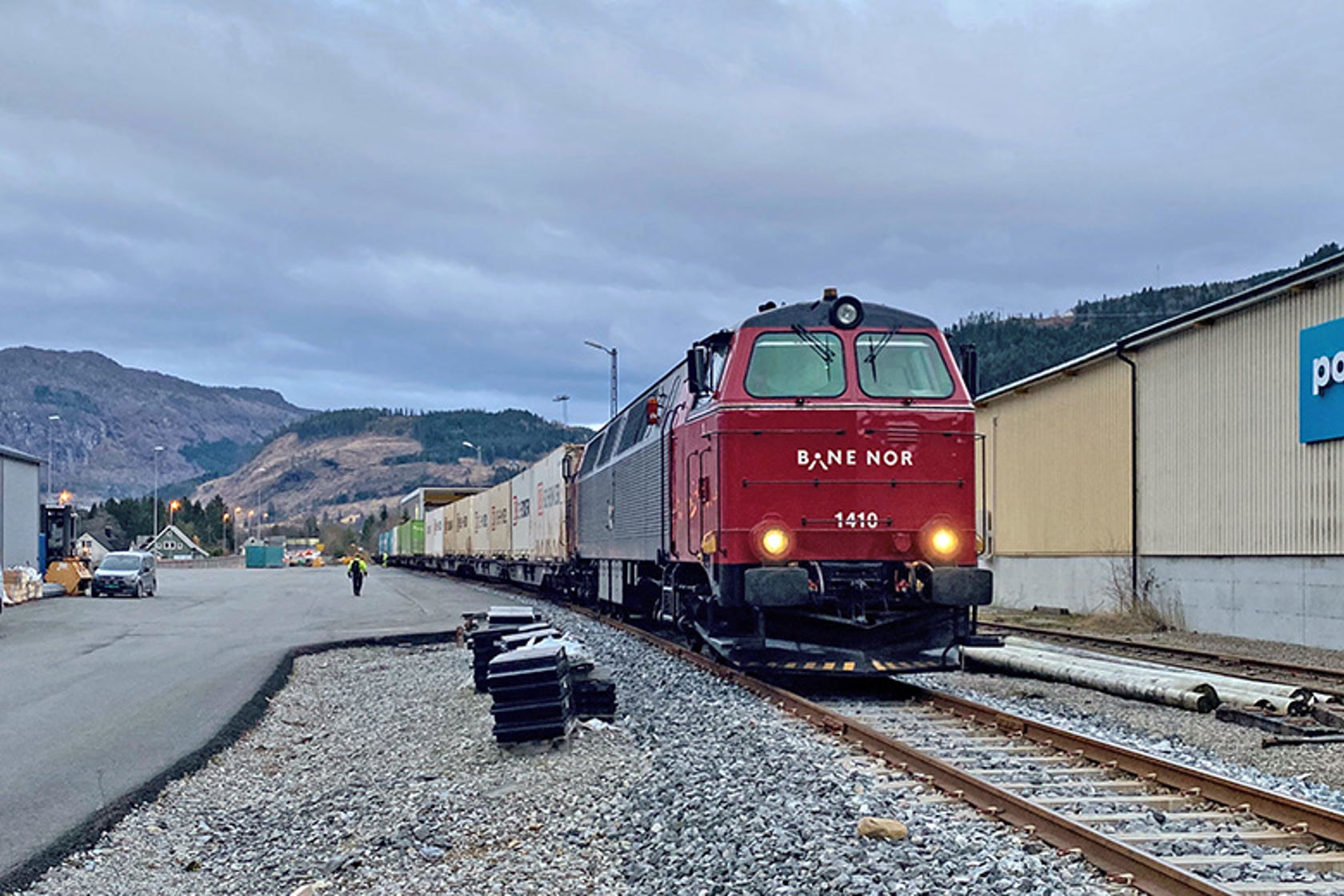 Et rødt godstog kjører på et jernbanespor