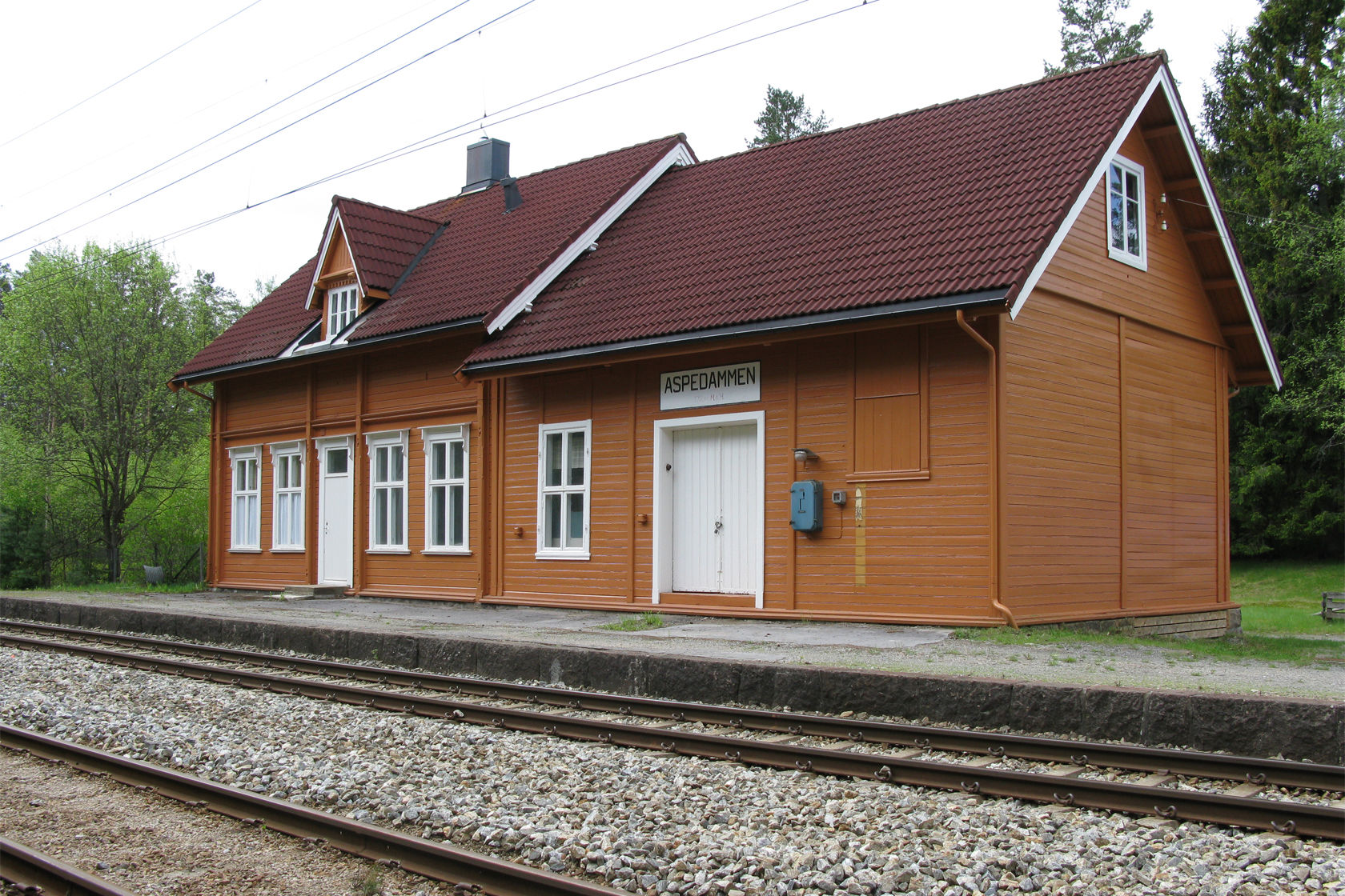 Aspedammen station building with tracks in front.