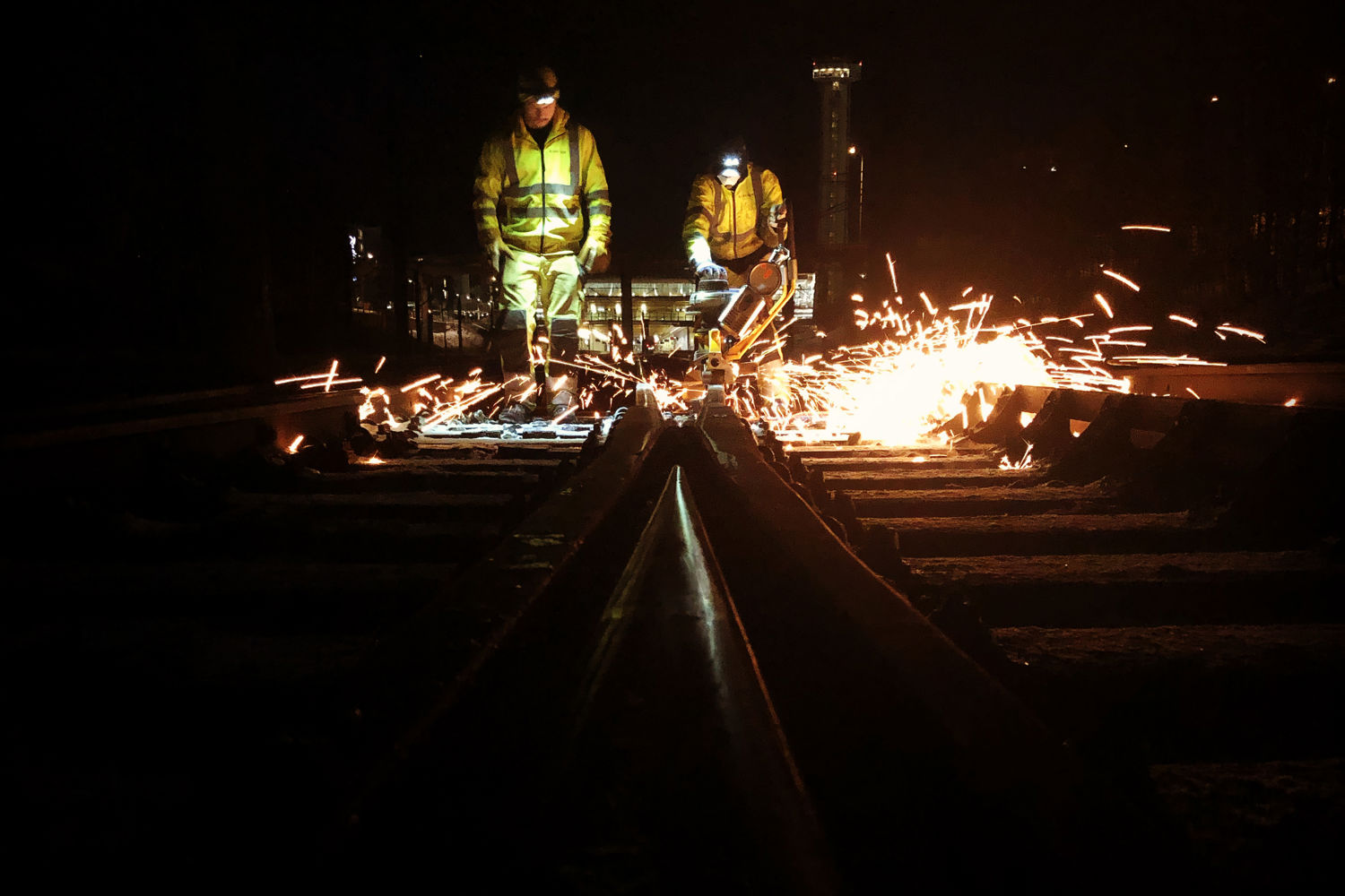 Arbeidere sveiser på jernbanesporet