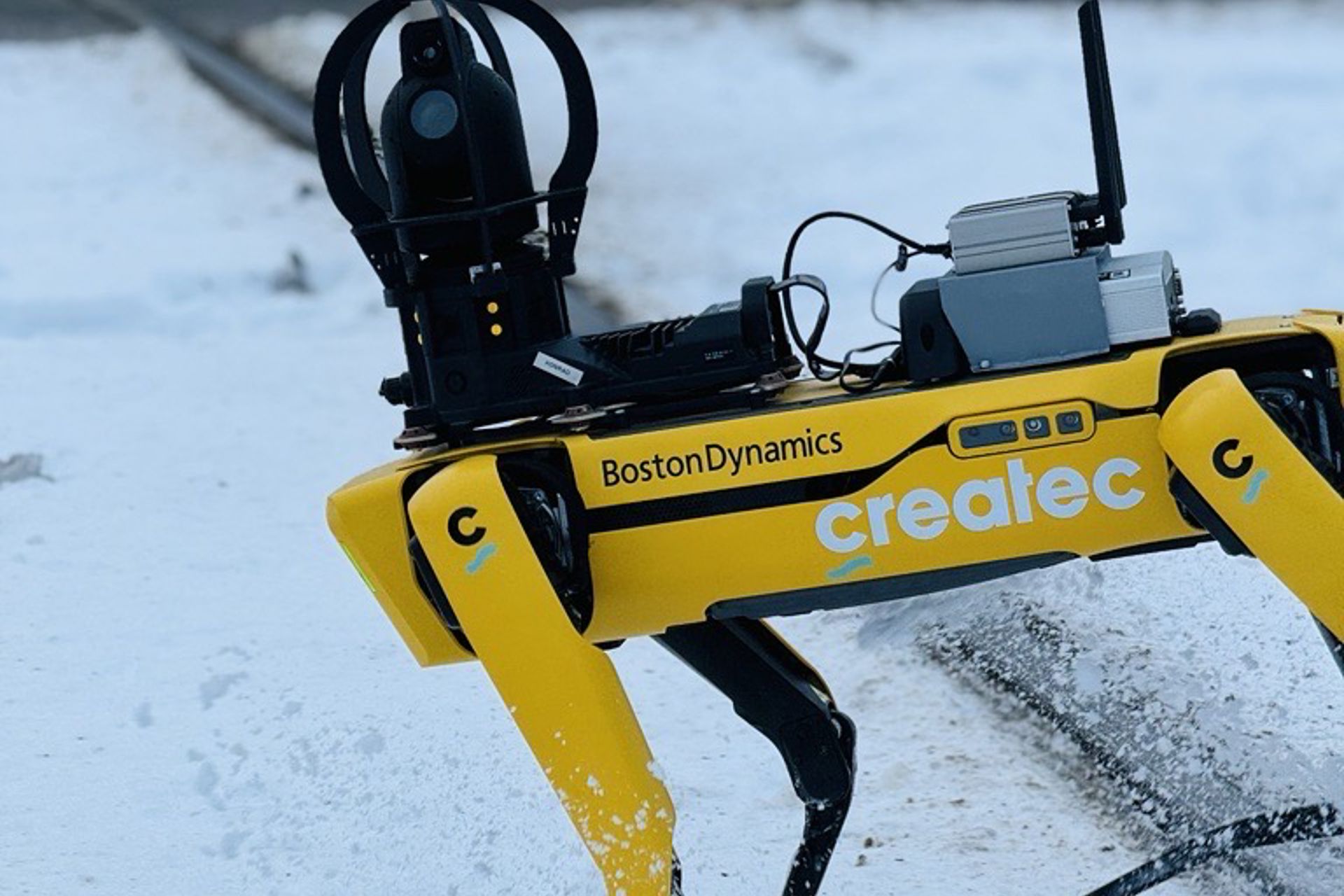 Gul robothund på godsterminal med snø på bakken